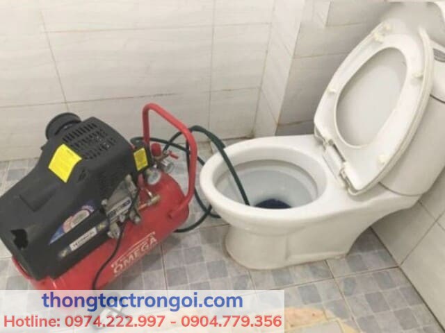 Dây máy lò xo thông tắc đang được đưa vào bồn cầu để xử lý tắc nghẽn