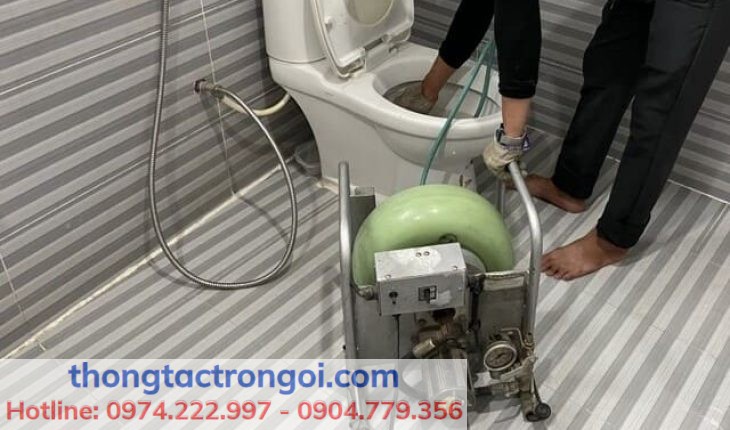 Thợ thông tắc bồn cầu đang sử dụng máy lò xo công suất lớn tại nhà dân