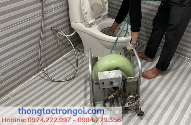 Thợ thông tắc bồn cầu đang sử dụng máy lò xo công suất lớn tại nhà dân