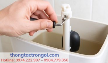 Người dùng đang chỉnh vít nhựa trên phao dạng cây của bồn cầu INAX để tiết kiệm nước.