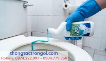 Thao tác xịt dung dịch tẩy rửa bồn cầu chuyên dụng lên nắp nhựa.