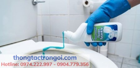 Thao tác xịt dung dịch tẩy rửa bồn cầu chuyên dụng lên nắp nhựa.