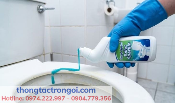 Thao tác xịt dung dịch tẩy rửa bồn cầu chuyên dụng lên nắp nhựa.