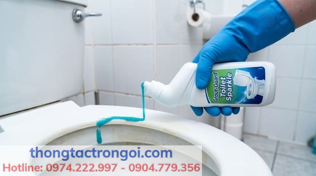 Thao tác xịt dung dịch tẩy rửa bồn cầu chuyên dụng lên nắp nhựa.